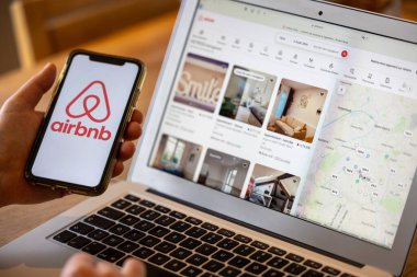 Paris, Fransa - 30 Kasım 2023 Airbnb uygulamalı akıllı telefonu tutan kadın. Airbnb, insanların kısa vadeli konaklama veya kiralama olanağı sağlayan çevrimiçi bir pazar ve konaklama hizmetidir.