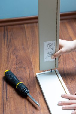 Öğrenci mobilya monte ediyor.