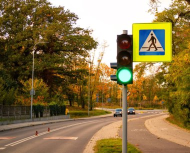 Yaya geçidi tabelası, trafik lambası ve arabalar için yeşil ışık..