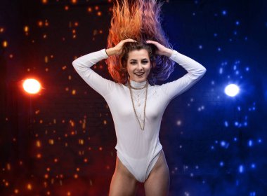 Genç bir kadın hoparlör gibi dans ediyor. Kırmızı ve mavi ışıkla aydınlatılıyor. Ateş ve buz gibi..