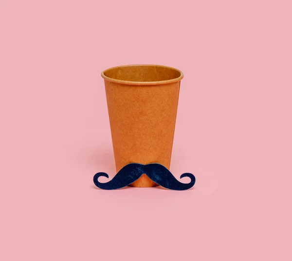 Craft paper glass with a male mustache on a pink background