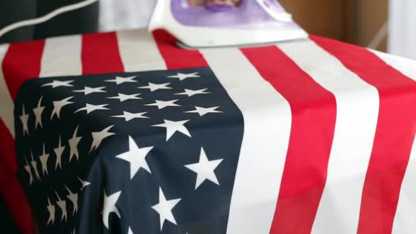 一个男人在桌上烫着美利坚合众国的国旗 美国独立日假期的筹备工作 — 图库视频影像