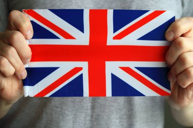 İngiliz bayrağının yakın çekimi, erkeklerin elinde. Büyük Britanya bayrağı.