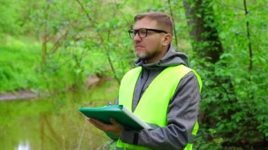 Erkek ekolojist, çevrenin durumunu kaydeder. Çevre denetimi.