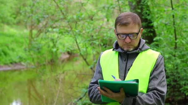 Männliche Ökologe Macht Aufzeichnungen Über Den Zustand Der Umwelt Waldfluss — Stockvideo