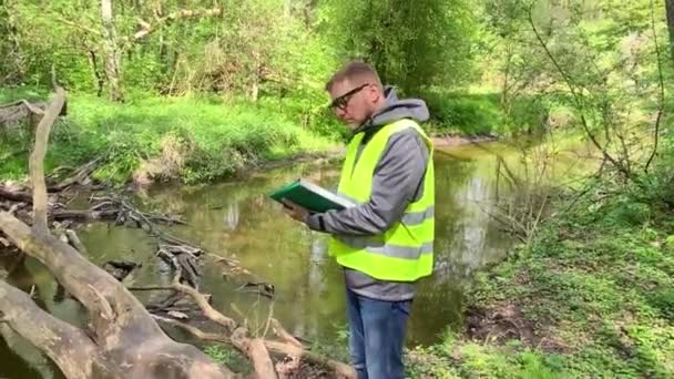 Męski Ekolog Zapisuje Stan Środowiska Leśnego Rzeki Kontrola Środowiska — Wideo stockowe