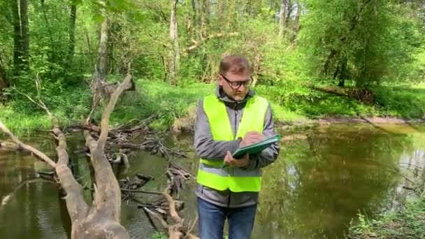 男性生態学者は環境森林河川の状態を記録している 環境管理 — ストック動画