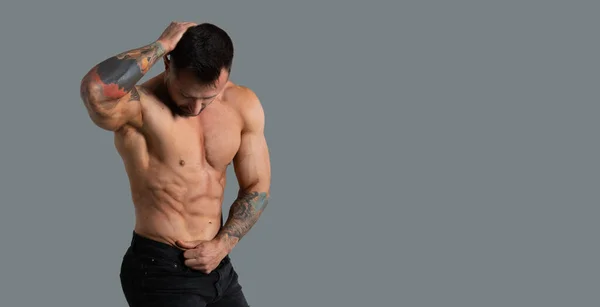 Man Bodybuilder Med Utvecklade Kroppsmuskler Grå Bakgrund Horisontell Banderoll Ort — Stockfoto