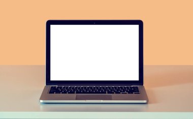 Dairedeki şeftali pembesi bir duvarın arka planına dayalı boş beyaz ekranlı dizüstü bilgisayarın görüntüsü. Çevrimiçi kurslar hakkında bilgi için modelleme.