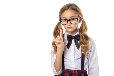 Ciddi bir liseli kızın uyarı parmağı gösteren portresi, okula geri dönüyor. 9 yaşında bir kız. Beyaz bir arkaplanda izole edilmiş.