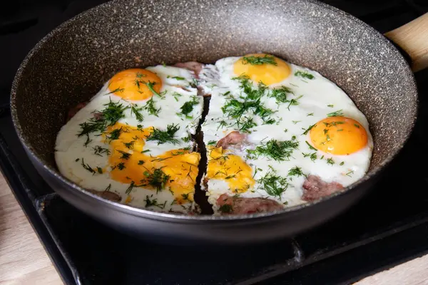 İki kişilik omlet. Yağda yumurta ve sosisli kızartma tavası iki parçaya ayrılır. Dereotlu taze kızarmış yumurta..