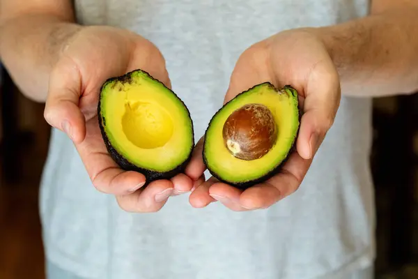 Male Hands Hold Two Halves Avocado Sliced Avocado Preparing Dietary — Stock Photo, Image