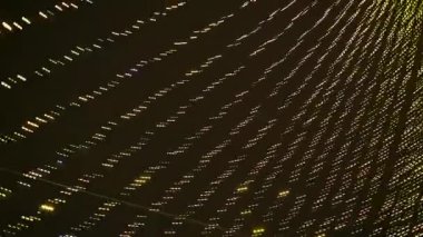 Süslü bir Noel ağacının yanında asılı çelenklerle dönüyor. Bokeh etkisi ile hareket halindeki sokak ışıkları.