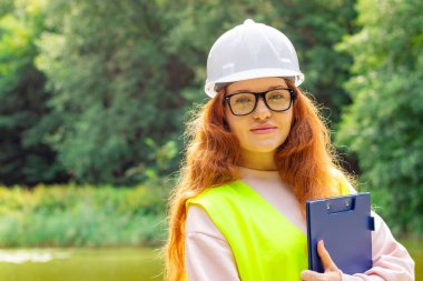 Çalışan ekolojist kadın. Orman kontrol müfettişi. Dosyası olan kadın ekolojik teknisyen. Orman mühendisi..