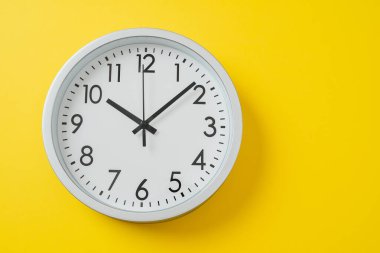 Sarı arka planda sarı yuvarlak saat. Sarı arkaplandaki saat. Başlamak için iyi bir zaman. Yaz zamanı, afiş. Saat 2 'ye 10 dakika var, mesaj için boşluk.