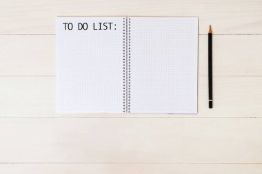Liste yapmak için. Kalem ve listeyi spiral deftere yazmak için, düz bir şekilde açık ahşap masaya uzanın.