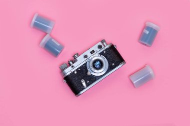 Retro fotoğraf makinesi ve pembe arka planda film, düz yatış tarzı. Hippi fotoğrafçı..