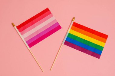 Pembe arka planda iki LGBT bayrağı. Gökkuşağı bayrağı ve lezbiyen bayrağı.