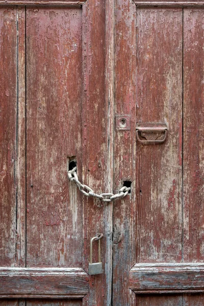 老旧的粗糙木门 有门栓和门锁 钢铁和木材的详细情况 图库照片