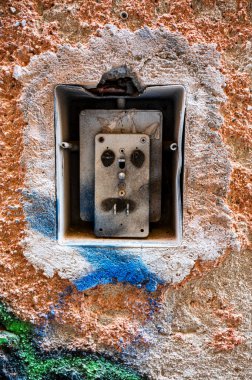 Dışardaki lamba düğmesi kırılmış ve boyayla bozulmuş. Fotoğraf konsepti. Çürüyen dış duvar.