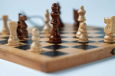 Beyaz tabanlı ve arka planlı satranç tahtasındaki siyah ve beyaz satranç taşlarının yakın çekimi