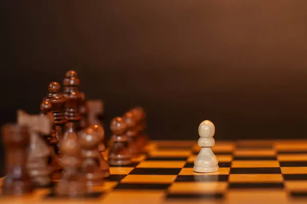 Koyu arkaplanda tahta üzerinde satranç taşları