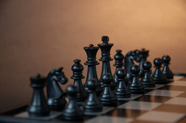 Koyu arkaplanda tahta üzerinde satranç taşları