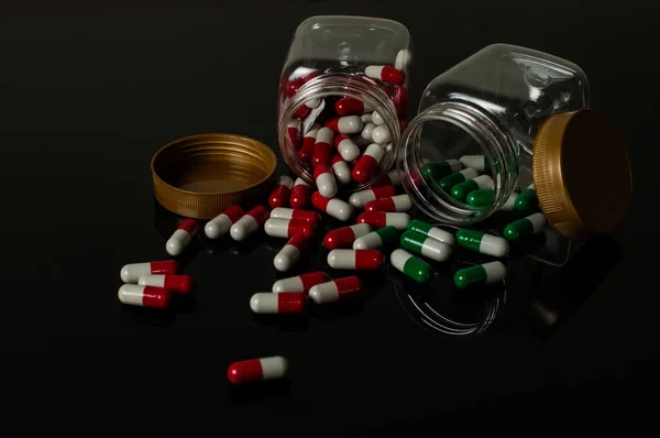 photo of medication in a bottle, strewn outside the bottle and near it is a syringe with a dark background showing the dangers of using medication if it is not in accordance with its use and dosage
