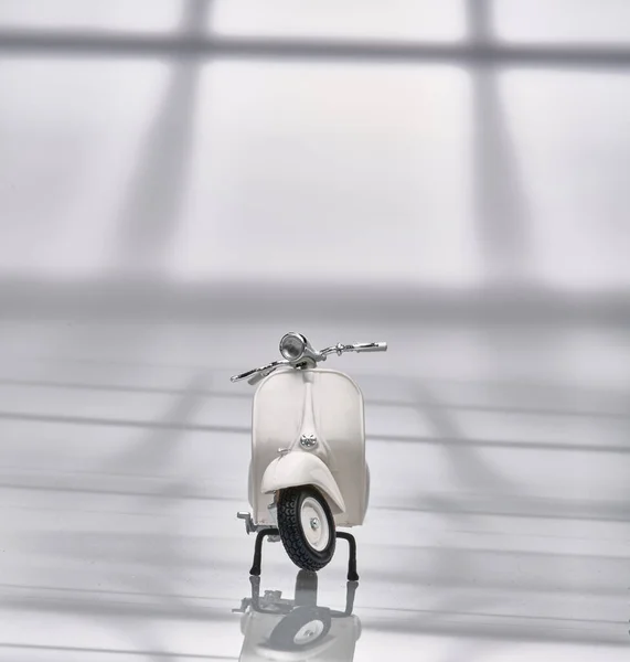 Eski bir minyatür Vespa 'nın fotoğrafı. Ayrıca scooter olarak da bilinir. Beyaz Vespa nesnesini izole etmek için hafif bir arkaplan ile fotoğraflandı