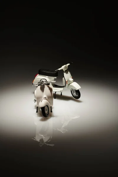 Eski bir minyatür Vespa 'nın fotoğrafı. Ayrıca scooter olarak da bilinir. Beyaz Vespa nesnesini izole etmek için çok parlak olmayan bir arkaplan ile çekilmiş.