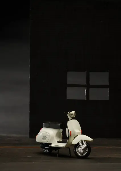 Eski bir minyatür Vespa 'nın fotoğrafı. Ayrıca scooter olarak da bilinir. Beyaz Vespa nesnesini izole etmek için çok parlak olmayan bir arkaplan ile çekilmiş.