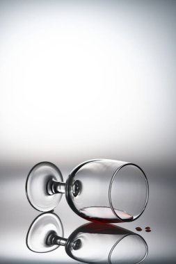 Arka planda kırmızı bir şarap bardağı ve cam duruşu.