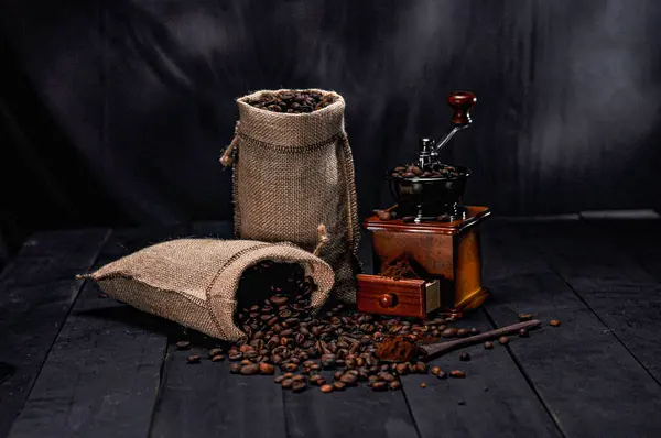 Koyu arkaplanda öğütücü ve kahve çekirdekleri