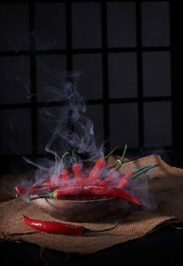 Pencere arkası ve loş bir atmosferi olan baharatlı ve fotoğraflı büyük kırmızı biber biberi.