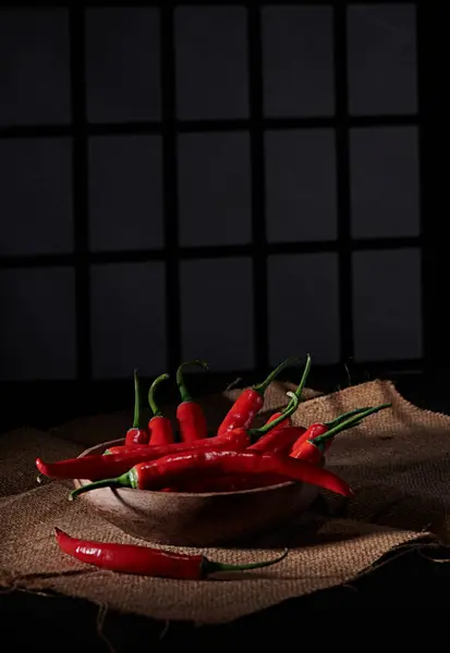 Pencere arkası ve loş bir atmosferi olan baharatlı ve fotoğraflı büyük kırmızı biber biberi.