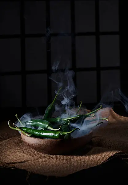Pencere arkası ve loş bir atmosferi olan baharatlı ve fotoğraflı büyük kırmızı biber biberi.