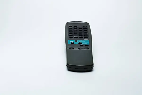 Büyük şeklinden görülebilen eski model uzaktan kumanda, kapağın durumu temiz değil. AC, TV ve Audio gibi elektronik ekipmanları açmak için kullanılır