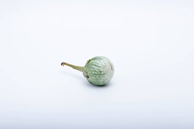 Sağlıklı yeşil yuvarlak patlıcan. Beyaz tabanlı ve arka planda çekilmiş sebze.