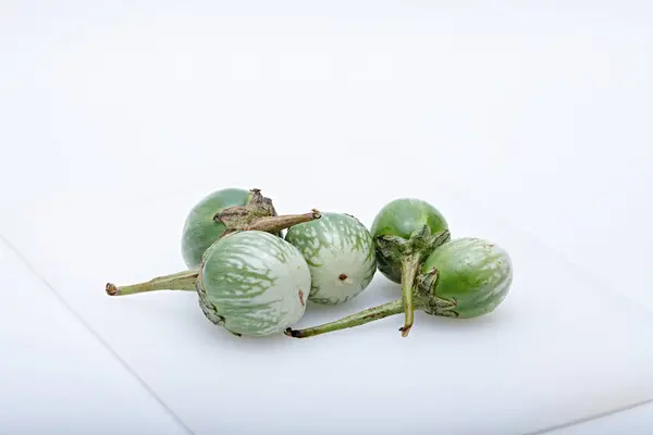 Sağlıklı yeşil yuvarlak patlıcan. Beyaz tabanlı ve arka planda çekilmiş sebze.