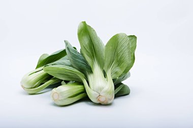 Fresh pak choy vegetables placed on a plastic chopping board in a photo with a white background clipart