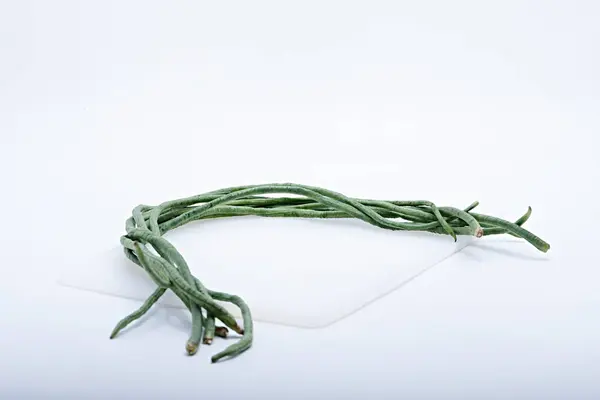 Beyaz ya da hafif bir zemin ve arka planla çekilmiş taze uzun fasulyeler.