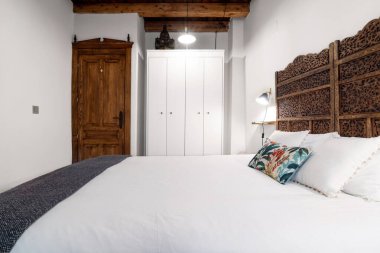 Yatak odasının içi ahşap tavan ve lambalarla döşenmiş ve odayı aydınlatıyor.