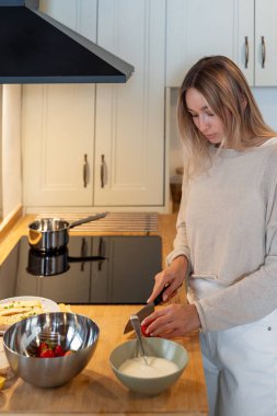 Beyaz kadın evde sağlıklı vegan kahvaltısı hazırlıyor.