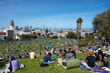 San Francisco, California - 25 Nisan 2023: İnsanlar mavi gökyüzüne karşı ilkbahar boyunca Dolores Park Misyonunda boş vakitlerin tadını çıkarıyorlar