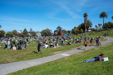 San Francisco, California - 25 Nisan 2023: İnsanlar mavi gökyüzüne karşı ilkbahar boyunca Dolores Park Misyonunda boş vakitlerin tadını çıkarıyorlar