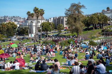 San Francisco, California - 25 Nisan 2023: İnsanlar mavi gökyüzüne karşı ilkbahar boyunca Dolores Park Misyonunda boş vakitlerin tadını çıkarıyorlar