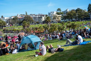 San Francisco, California - 25 Nisan 2023: İnsanlar mavi gökyüzüne karşı ilkbahar boyunca Dolores Park Misyonunda boş vakitlerin tadını çıkarıyorlar