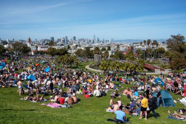 San Francisco, California - 25 Nisan 2023: İnsanlar mavi gökyüzüne karşı ilkbahar boyunca Dolores Park Misyonunda boş vakitlerin tadını çıkarıyorlar