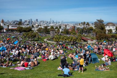 San Francisco, California - 25 Nisan 2023: İnsanlar mavi gökyüzüne karşı ilkbahar boyunca Dolores Park Misyonunda boş vakitlerin tadını çıkarıyorlar