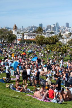 San Francisco, California - 25 Nisan 2023: İnsanlar mavi gökyüzüne karşı ilkbahar boyunca Dolores Park Misyonunda boş vakitlerin tadını çıkarıyorlar